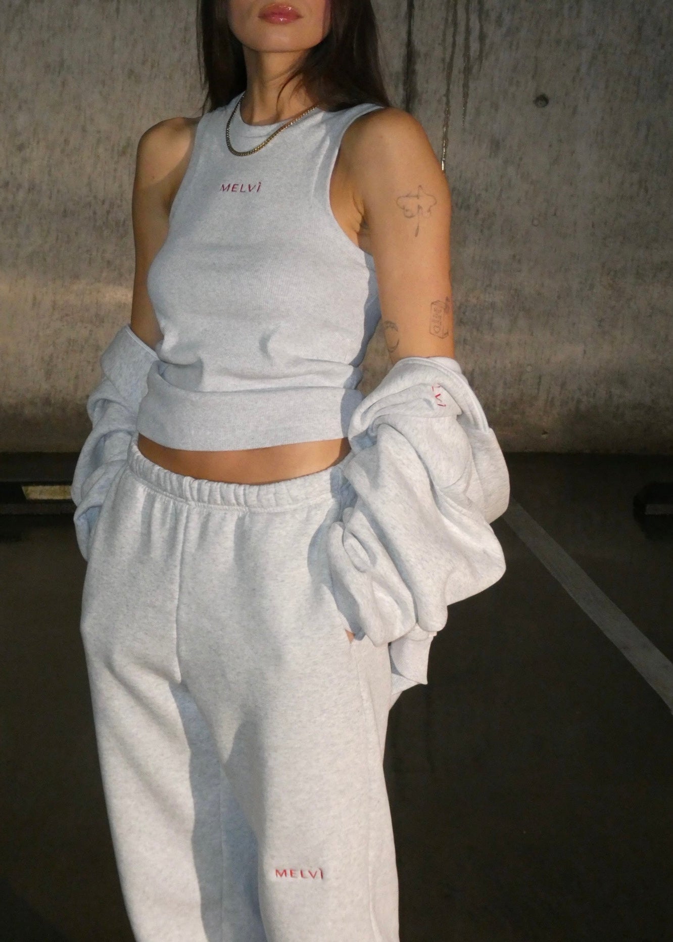 Person wearing a gray tracksuit with &